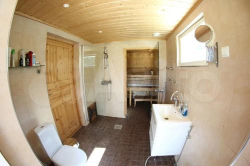 a small bathroom with a sink and a toilet at Modern cottage by the private lake in Lappeenranta