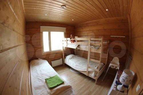 a room with two bunk beds in a log cabin at Modern cottage by the private lake in Lappeenranta