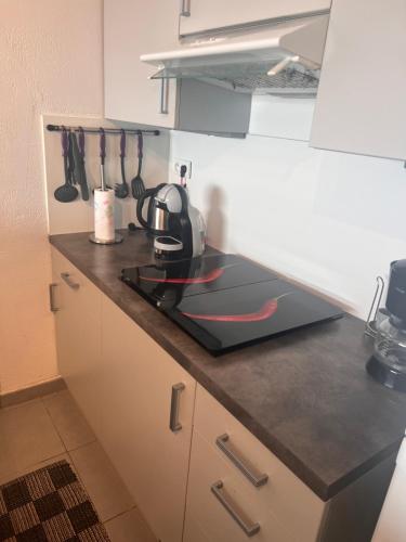 - un comptoir de cuisine avec une bouilloire et une cuisinière dans l'établissement Appartement vue mer, à Fréjus