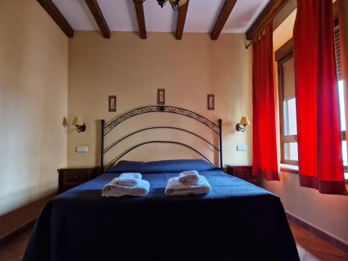 a bedroom with a bed with two towels on it at Hostal La Plata in Oropesa