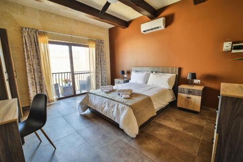 a bedroom with a bed and a large window at 49 Sunrise Lodge in Għajnsielem
