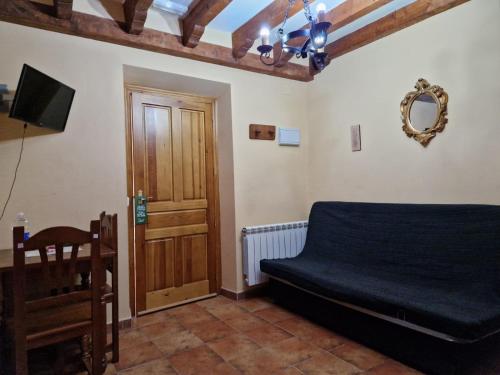 een slaapkamer met een bed en een houten deur bij Hostal La Plata in Oropesa