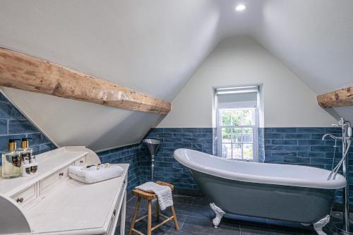 a bathroom with a large tub and blue tiles at Abbey Lodge in Llandudno