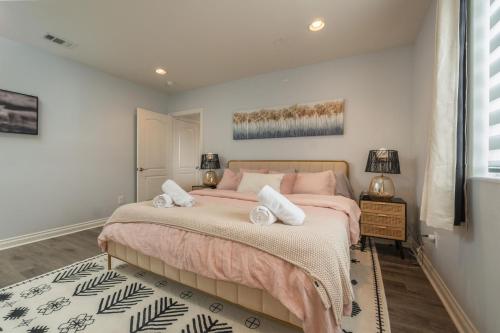 1 dormitorio con 1 cama grande y ropa de cama de color rosa en Angel & Rose * Hollywood DTLA en Los Ángeles