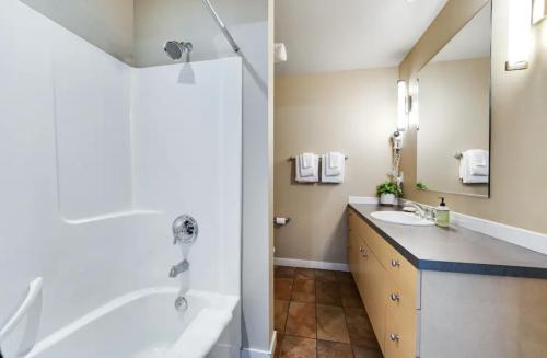 a bathroom with a tub and a sink at Chelan Resort Suites by DC in Chelan