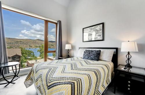 a bedroom with a bed and a large window at Chelan Resort Suites by DC in Chelan