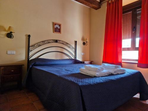 a bedroom with a blue bed with towels on it at Hostal La Plata in Oropesa