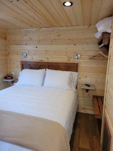 a bedroom with a white bed in a wooden room at 091 Star Gazing Tiny Home near Grand Canyon South Rim Sleeps 8 in Valle