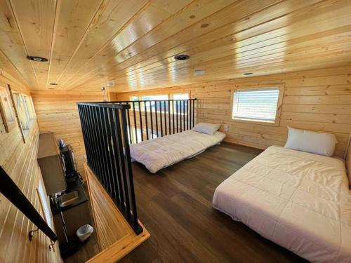 una camera con due letti in una cabina di legno di 091 Star Gazing Tiny Home near Grand Canyon South Rim Sleeps 8 a Valle