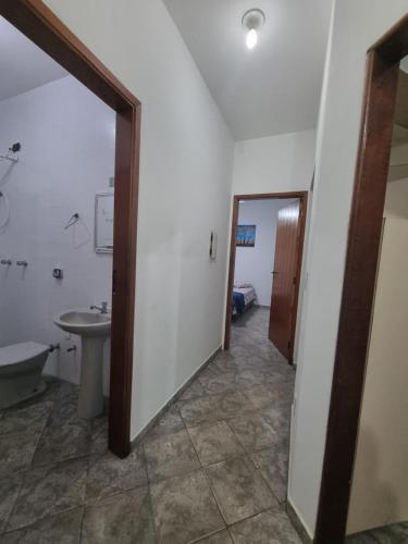 a hallway with a bathroom with a sink and a mirror at Casa Relaxemar in Caraguatatuba