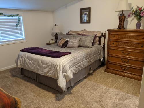 a bedroom with a bed with a dresser and a window at Cozy Lakeside Cottage in Green Mountain Falls