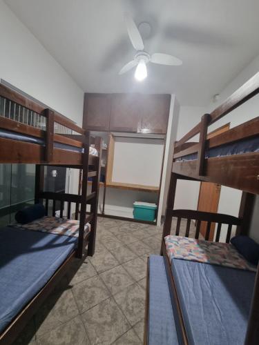 a room with three bunk beds and a ceiling fan at Casa Relaxemar in Caraguatatuba