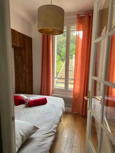 um quarto com 2 camas e uma janela com cortinas laranja em Cosy 2 pièces Parc Georges Brassens em Paris
