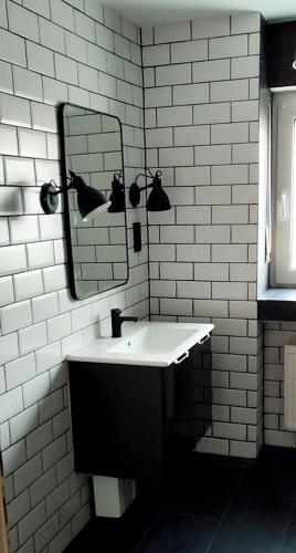 a white bathroom with a sink and a mirror at Südeifel Badem in Badem