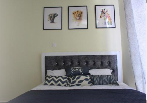SIMBA'S NOOK - A modern Budget Studio Apartment in Syokimau, Nairobi with Fast WiFi & Netflix - Near the JKIA Airport, SGR Station & Gateway Mall في Syokimau: غرفة نوم بسرير بأربع صور على الحائط