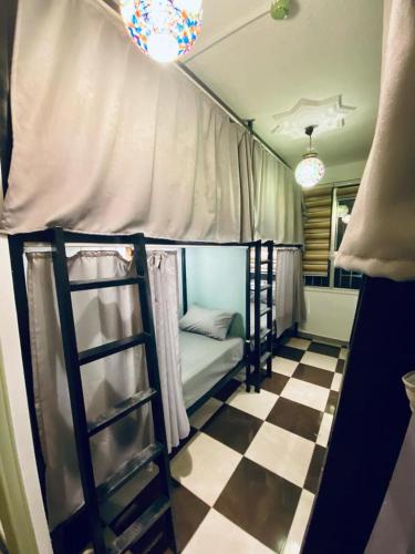 una stanza con un letto a castello e un pavimento a scacchi di Friends Oasis ad Aqaba