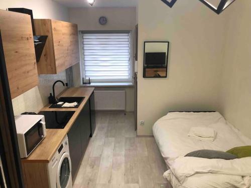 een kleine kamer met een bed en een magnetron bij Mazowiecka 29 Apartment B self check-in in Bydgoszcz