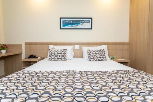 1 dormitorio con 1 cama grande con almohadas azules y blancas en Fluminense Hotel, en Río de Janeiro