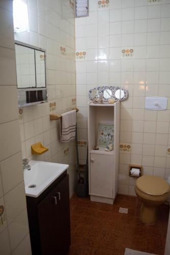 a bathroom with a toilet and a sink at Residencial Villalobos in Eldorado