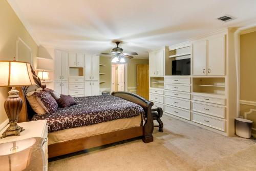 a bedroom with a bed and a television and white cabinets at Expansive Texas City Retreat about 16 Mi to Galveston! in Texas City
