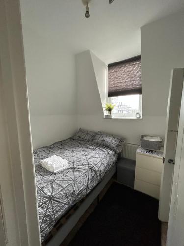 a small bedroom with a bed and a window at 1 Bed apartment with a balcony in London