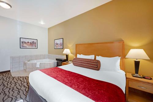 a hotel room with a bed and a bath tub at Best Western Plus Guymon Hotel & Suites in Guymon