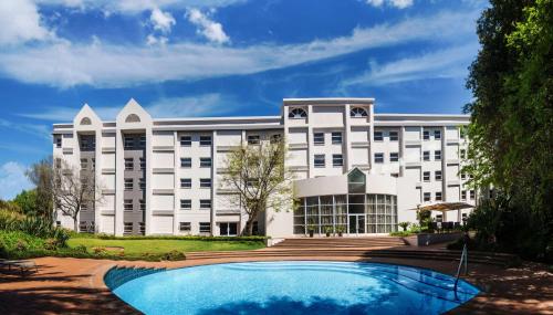 un edificio con piscina frente a él en StayEasy Eastgate en Johannesburgo