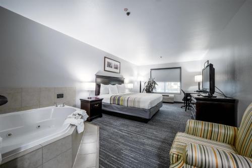 a hotel room with a bed and a tub and a bedroom at Country Inn & Suites by Radisson, Ontario at Ontario Mills, CA in Ontario