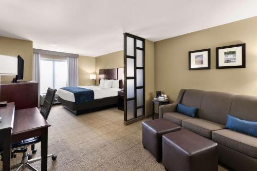 Habitación de hotel con cama y sofá en Comfort Suites, en Commerce