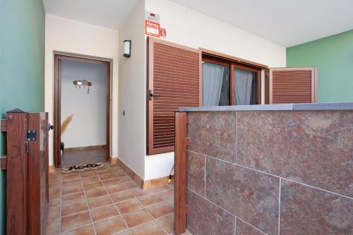 a room with a stone wall and a hallway with a door at Casa Dael in El Matorral
