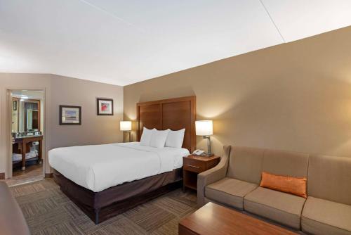 um quarto de hotel com uma cama e um sofá em Comfort Inn em Bangor