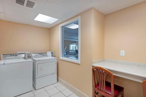 a laundry room with a washing machine and a window at Comfort Inn in Bangor