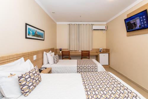 Postel nebo postele na pokoji v ubytování Fluminense Hotel