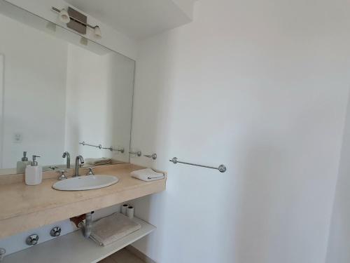La salle de bains est pourvue d'un lavabo et d'un miroir. dans l'établissement Luminoso Departamento, à Pinamar