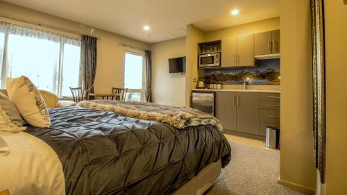 a bedroom with a bed and a kitchen at Blue Ridge Studios and Bed & Breakfast in Te Anau