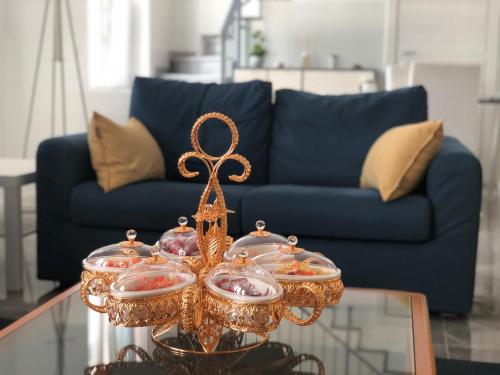 einen Glastisch mit einem Kronleuchter auf einem Tisch mit einer blauen Couch in der Unterkunft Welcome Milano Guest House in Mailand