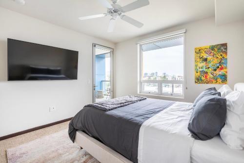 a bedroom with a large bed and a flat screen tv at Brand New 2BR WeHo Luxury Apartment in Los Angeles