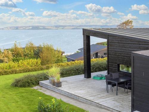 a house with a deck with a view of the water at 8 person holiday home in L gstrup in Løgstrup