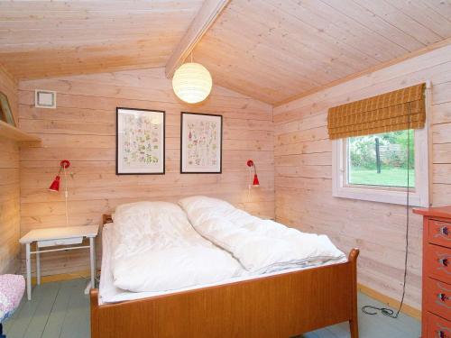 a bedroom with a bed in a wooden room at Holiday home Vig XLIII in Vig