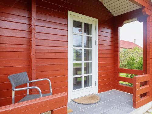 ein rotes Haus mit einem Stuhl auf einer Veranda in der Unterkunft 8 person holiday home in Vinderup in Vinderup