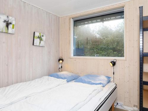 sypialnia z łóżkiem i oknem w obiekcie Holiday home Vestervig XLVII w mieście Vestervig