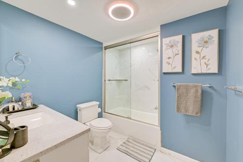 a blue bathroom with a toilet and a shower at New York Abode with Pool and Patio, Near Times Square! in Islip Terrace