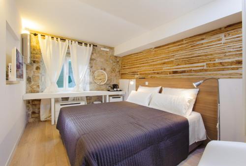 ein Schlafzimmer mit einem großen Bett und einem Schreibtisch in der Unterkunft Grgur Ninski Rooms in Split