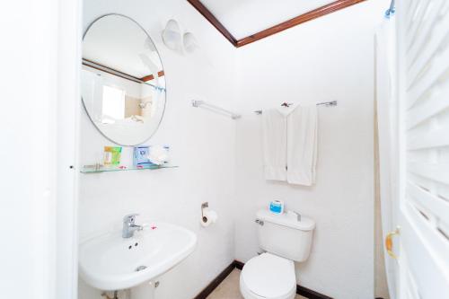 a bathroom with a sink and a toilet and a mirror at Franklyn D Resort & Spa All Inclusive in Runaway Bay