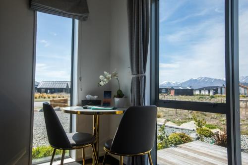 a room with a table and chairs in front of a window at Skyrim Lodge in Lake Tekapo