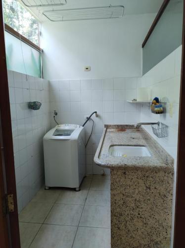 ウバトゥバにあるCasa em condominio fechado próximo a praiaのバスルーム(シンク、洗濯機付)