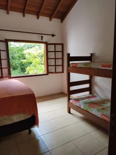 ウバトゥバにあるCasa em condominio fechado próximo a praiaのベッドルーム1室(二段ベッド2台、窓付)が備わります。