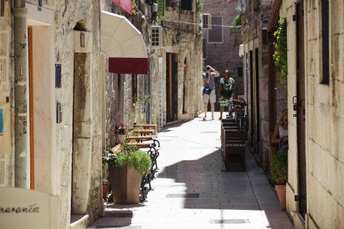 a couple of people walking down a street at Grgur Ninski Rooms in Split