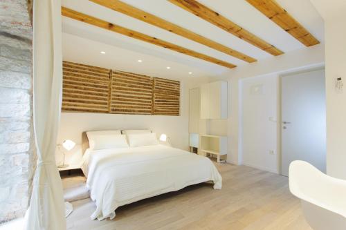 a bedroom with a white bed and wooden ceilings at Grgur Ninski Rooms in Split