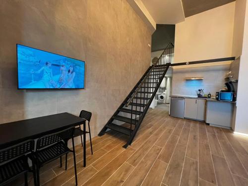 sala de estar con escalera y TV en la pared en Grandera Apart's - Cervero 24A en Valencia